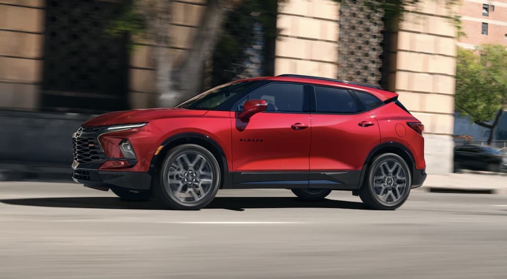 A red 2023 Chevy Blazer driving in a city.