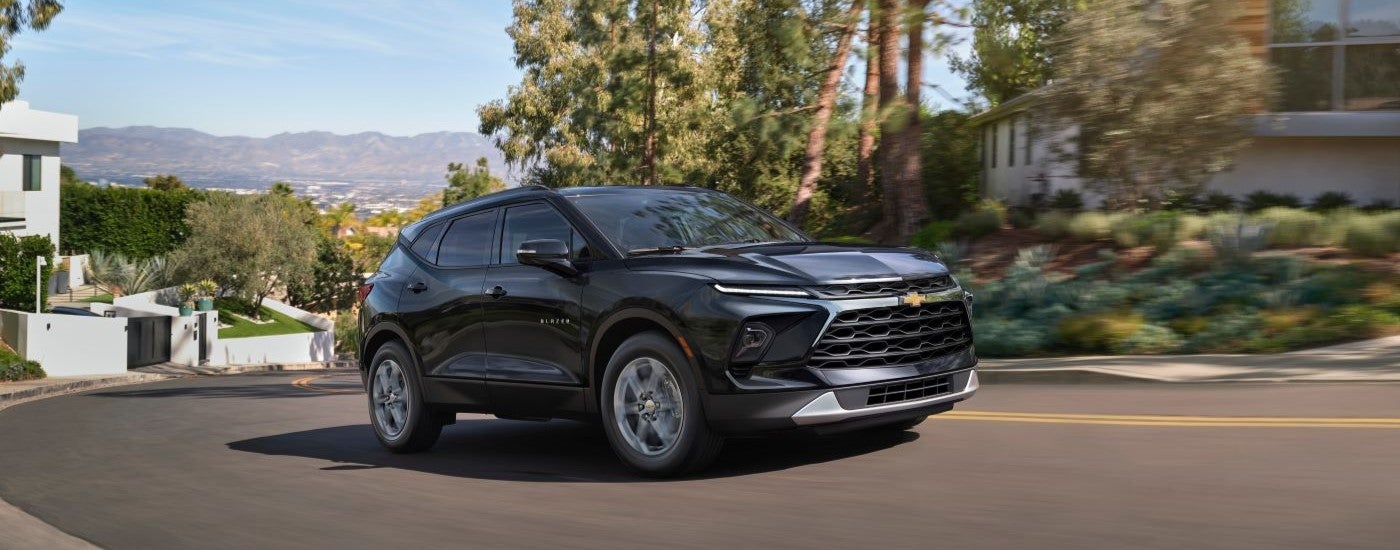 Black 2025 Chevy Blazer for sale in China Township driving around a bend