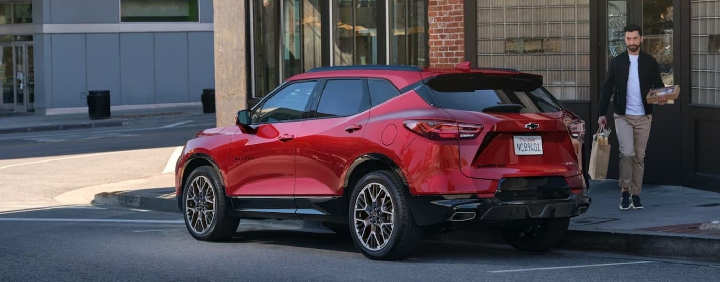 Rear of a red 2024 Chevy Blazer RS parked by a curb.