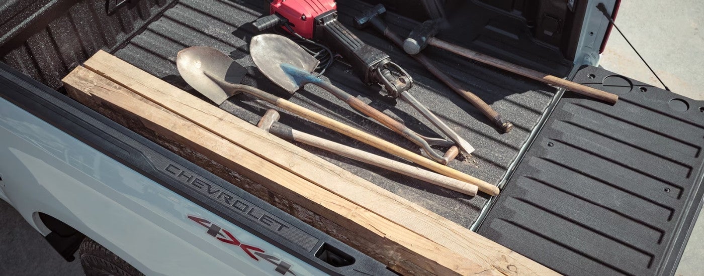 Tools in the bed of a white 2024 Chevy Silverado 1500.