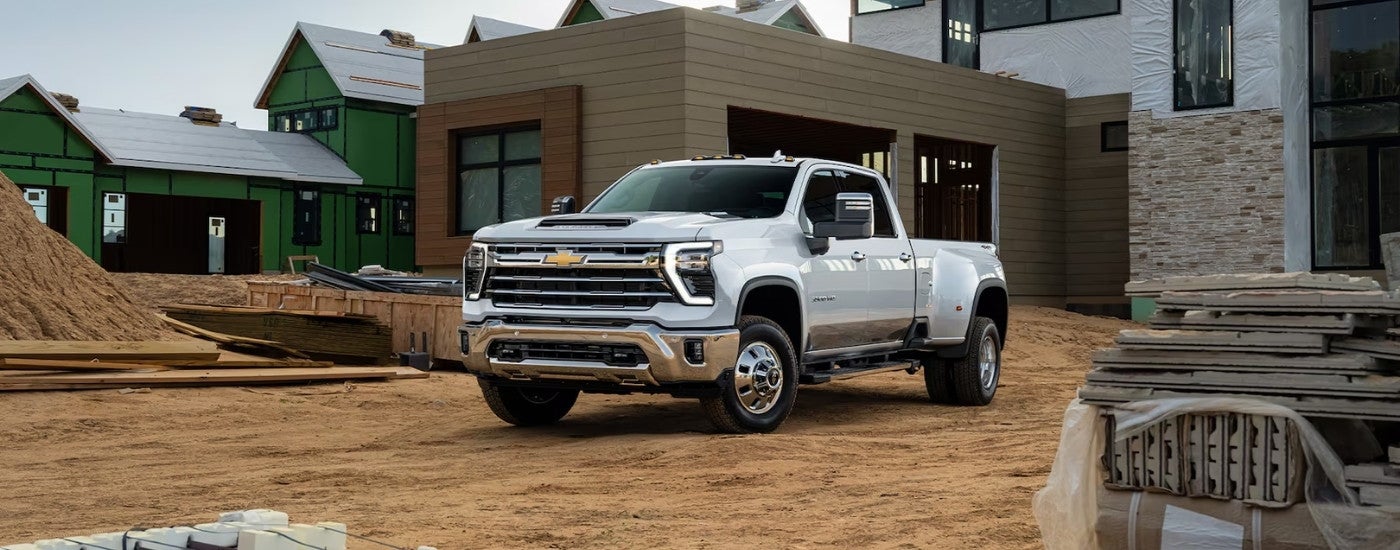 A white 2024 Chevy Silverado 3500 parked on a construction site.