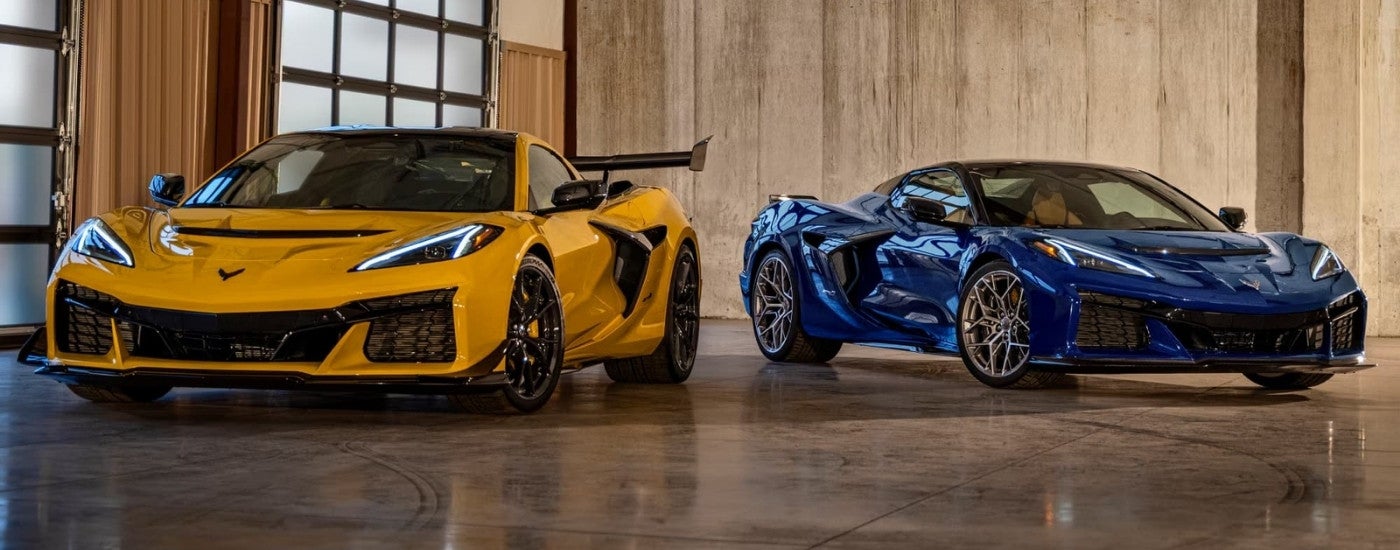 A yellow and a blue 2025 Chevy Corvette ZR1 parked at a used car dealership near Mount Clemens