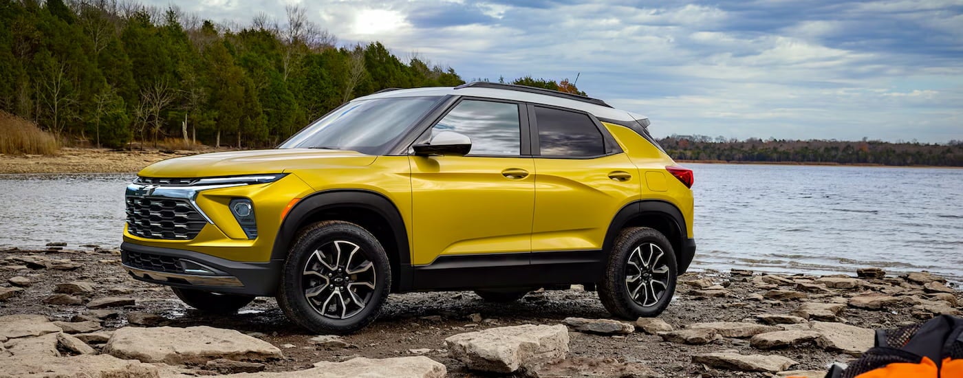 Yellow 2026 Chevy Trailblazer parked off-road near a lake.