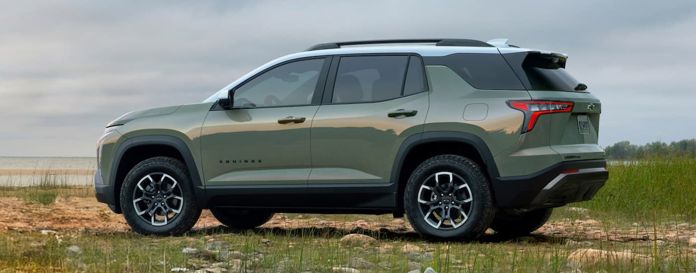 Side of a green 2026 Chevy Equinox parked off-road.