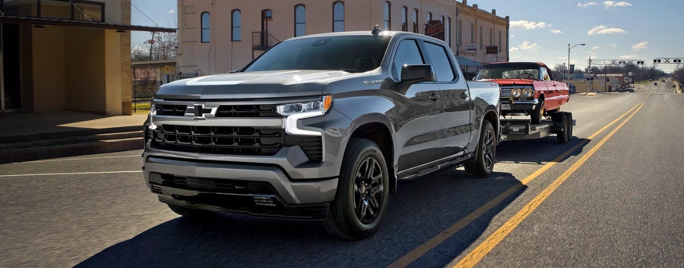Silver 2026 Chevy Silverado 1500 driving down a road.