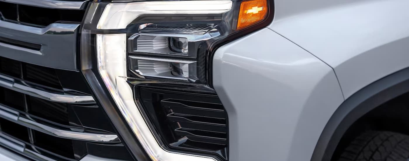 The driver side headlight on a white 2024 Chevy Silverado 3500 HD LTZ at a Chevy dealer.
